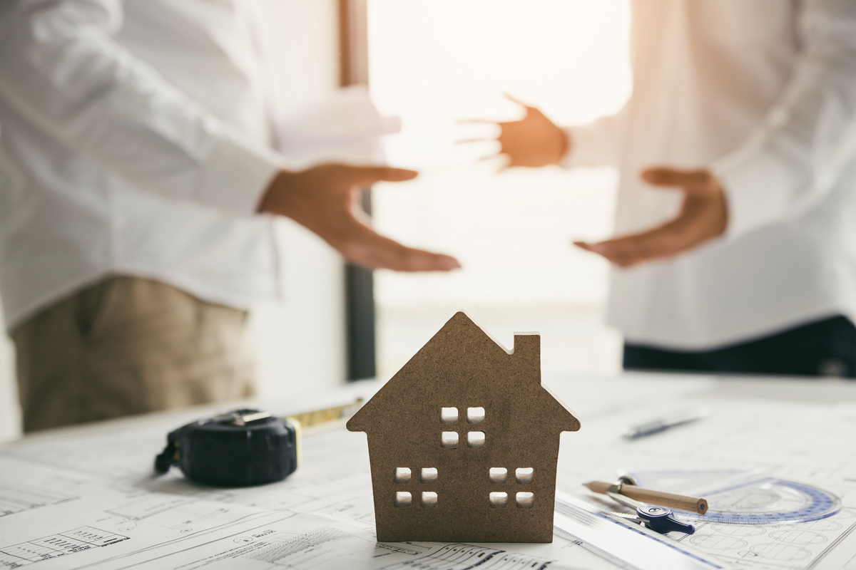 2 personnes négocient devant une maison